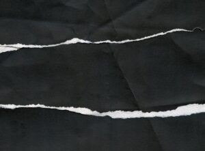 a piece of black and white paper with torn edges